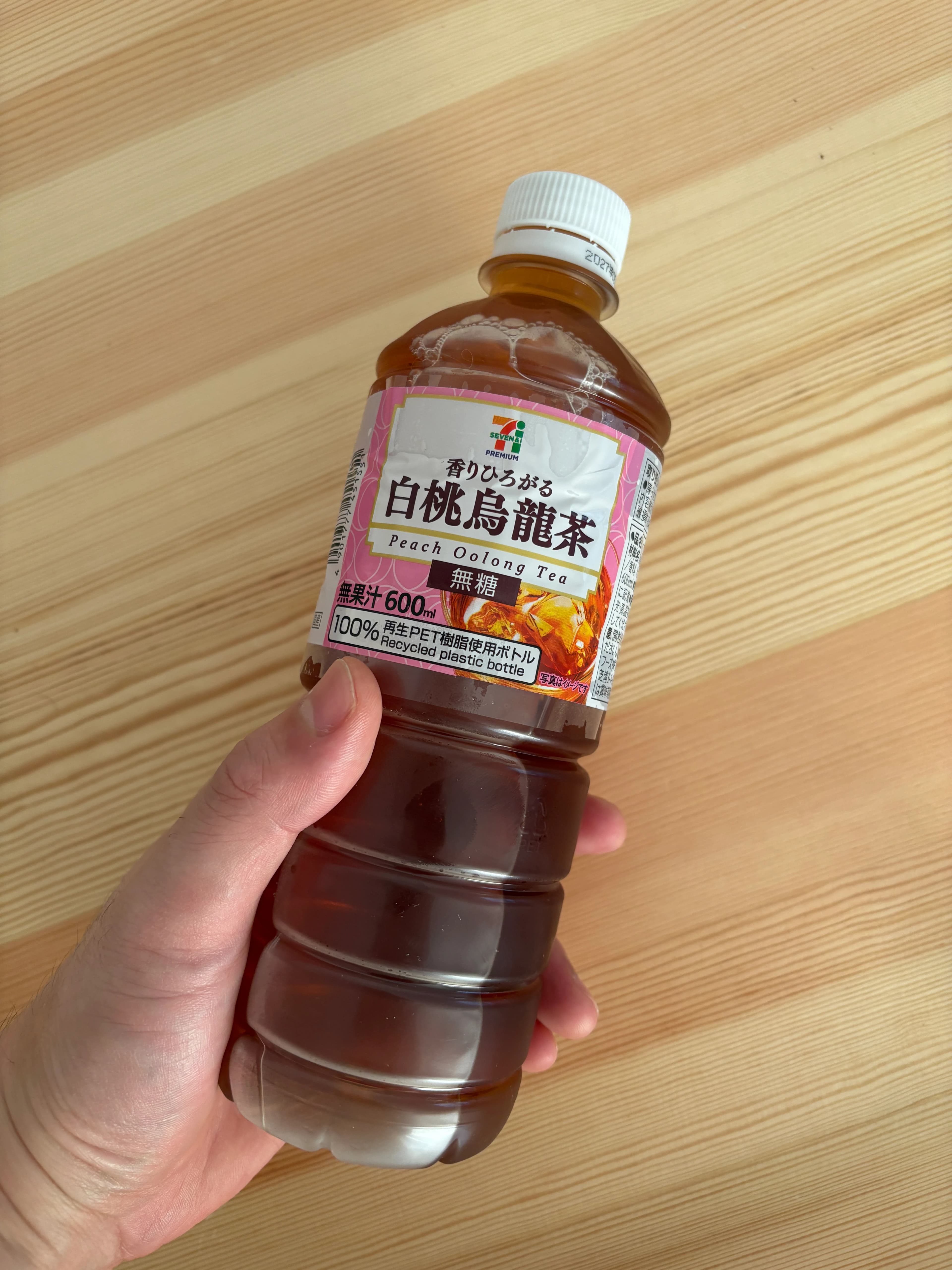 手に持ったセブンプレミアムの白桃烏龍茶